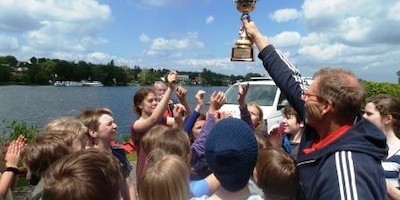 Schüler-Drachen mit Schuljahresfinish auf dem Wasser