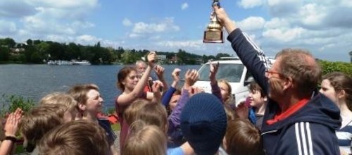 Schüler-Drachen mit Schuljahresfinish auf dem Wasser